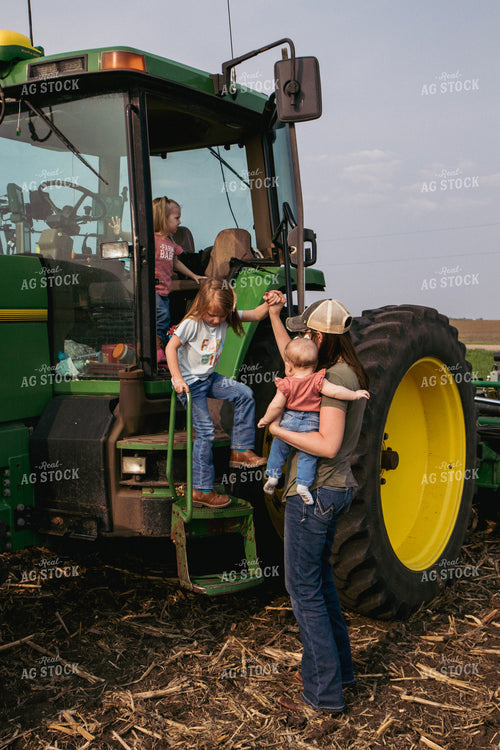 Female Farmer Helps Daughters Down Tractor Ladder in Freshly Planted Field 67299
