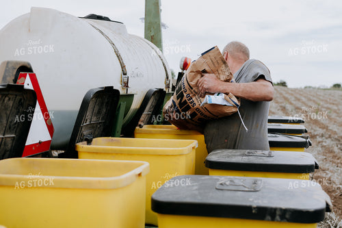 Farmer Filling Planter Boxes 77072