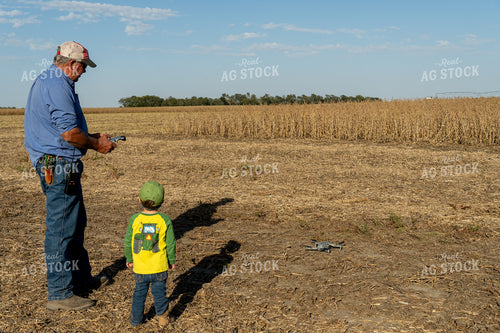 Farmer and Farm Kid Fly Drone in Field 65085