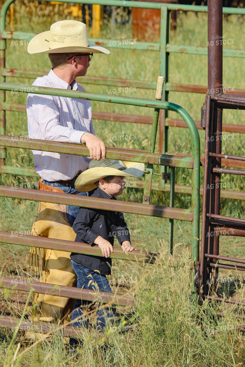 Rancher and Son Leaning on Fence 63083