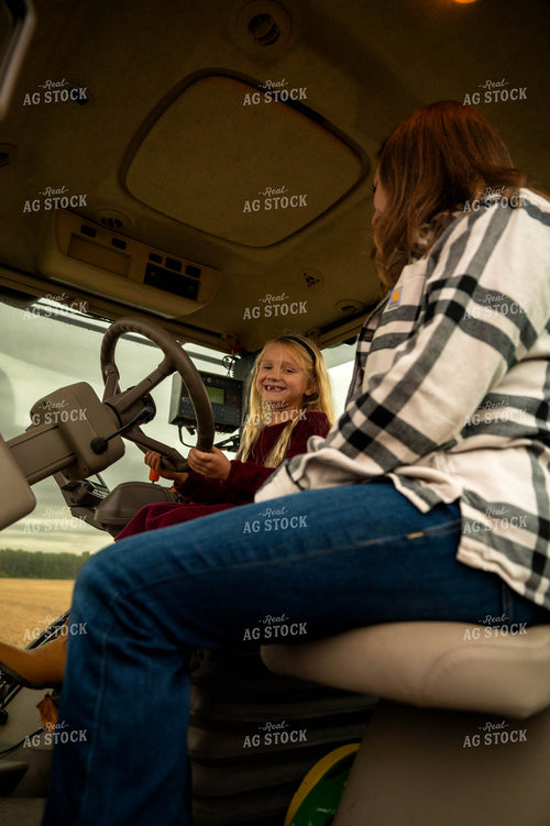 Female Farmer and Daughter in Tractor 115420