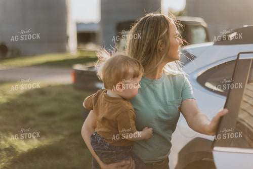 Woman Farmer Holds Child While Getting in Car 7653