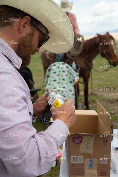 Rancher Prepares Medicine for Cattle 130024