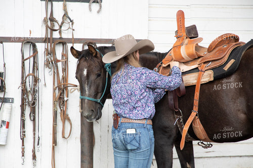 Female Rancher Tacking Horse 117106