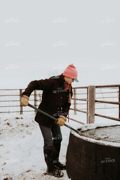 Female Rancher Breaking Up Water Trough 61180