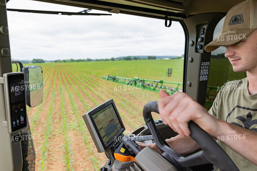 Farmer Driving Sprayer with Equipment Monitors Visible 79298