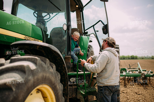 Farmer Helping Son Out of Tractor 169078