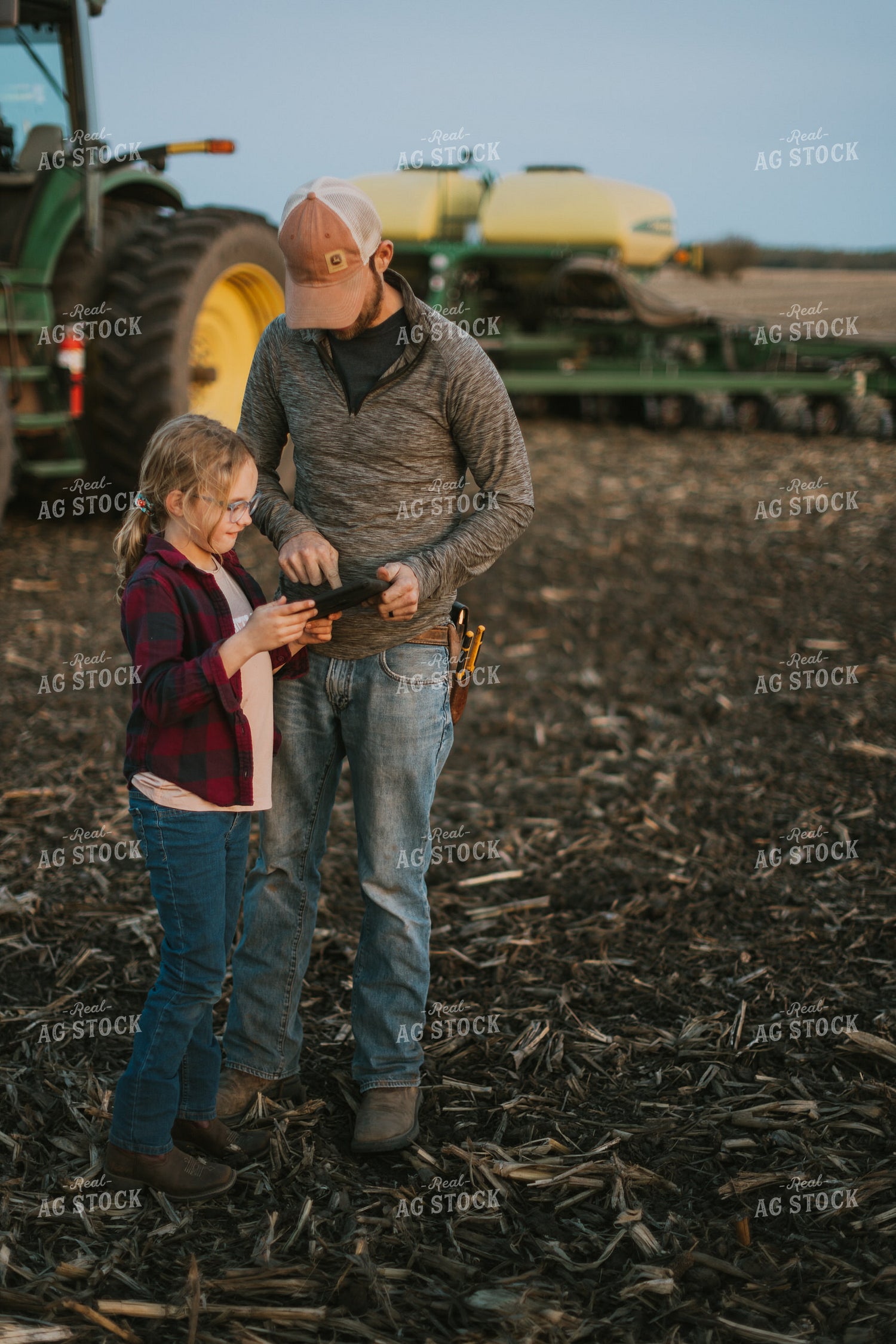 Farmer using Tablet in Field by Planter with Daughter 8262