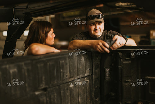 Farmers Talk and Use Phone While Leaning on Truck Bed 7585