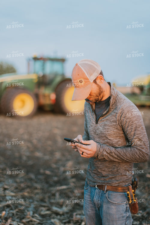 Farmer using Phone in Field by Planter 8246