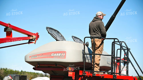 Farmer Loading the Planter with the Seed Tender 25098