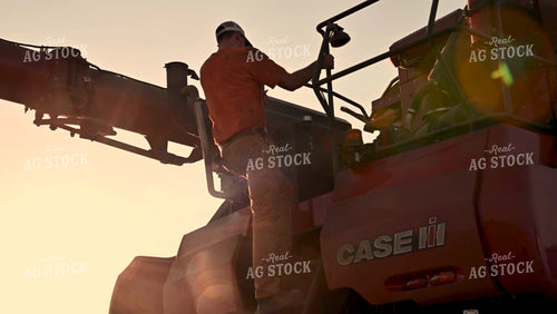 Farmer Climbing off Combine at Sunset - 428