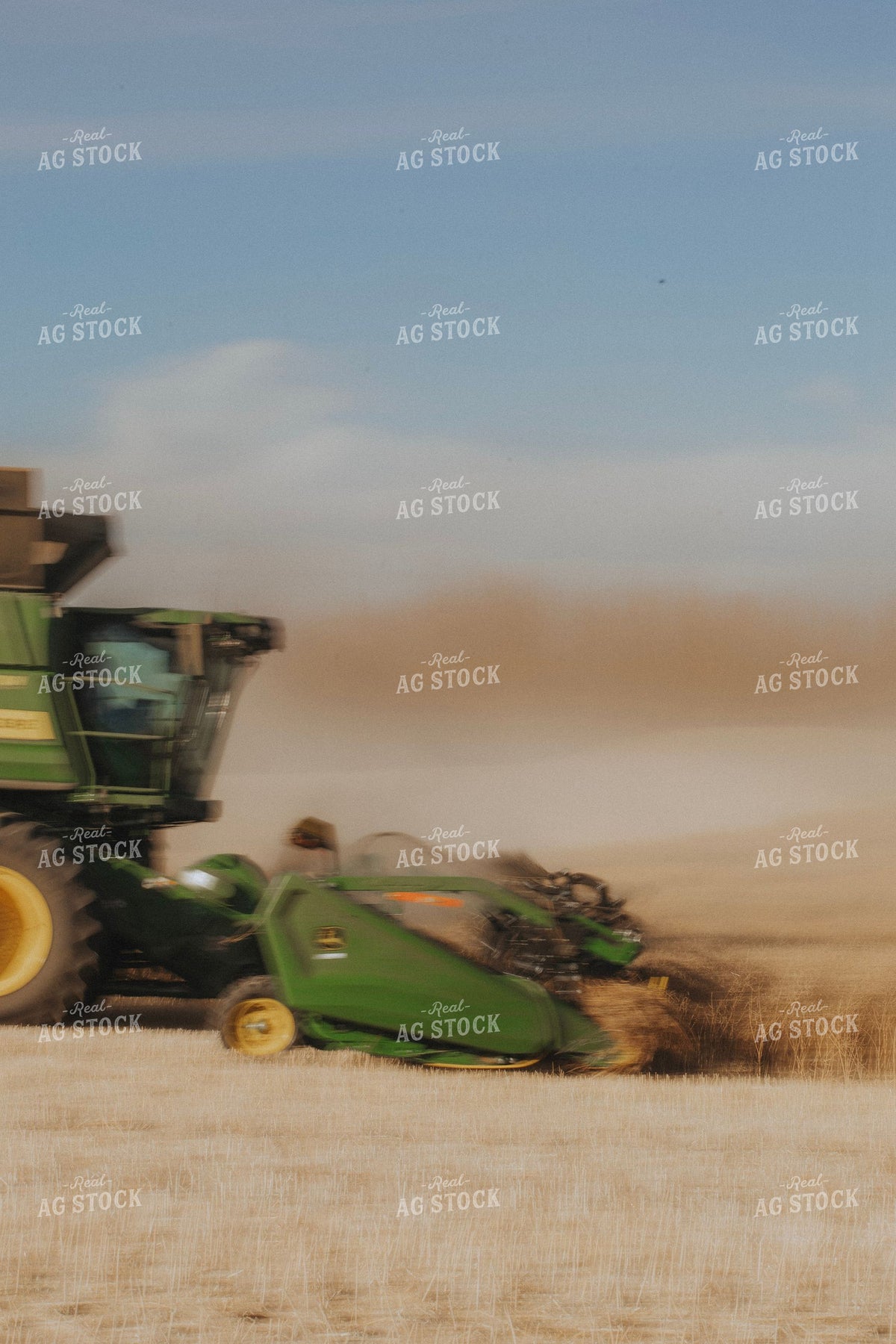 John Deere Combine Harvesting Wheat in a Dusty Field with Motion Blur 413008