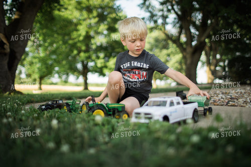 Farm Kid Playing with Toy Farm Machinery 5950