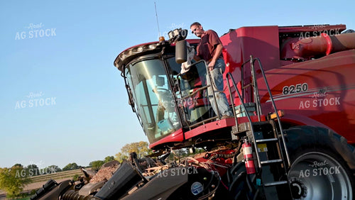 Farmer Cleaning Dust off Combine