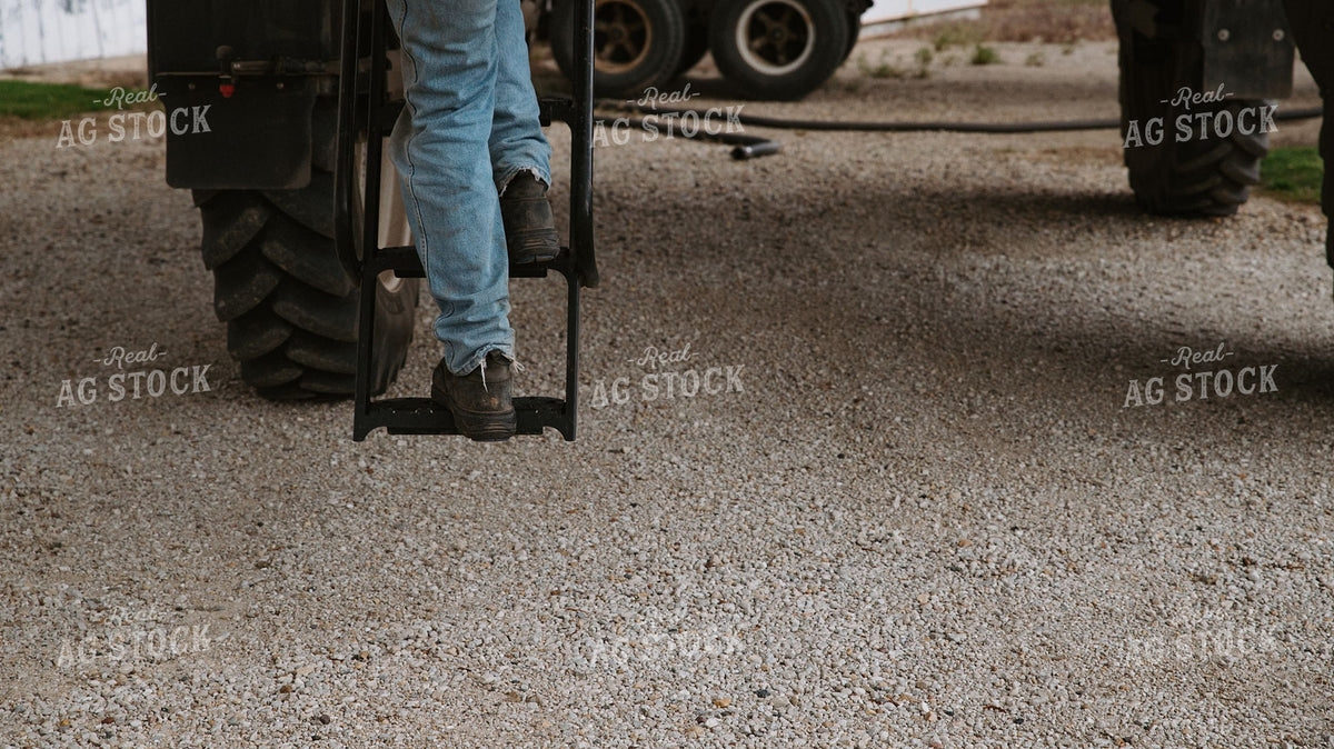 Farmer Climbing Down from Sprayer Steps on Gravel Farmyard 401007