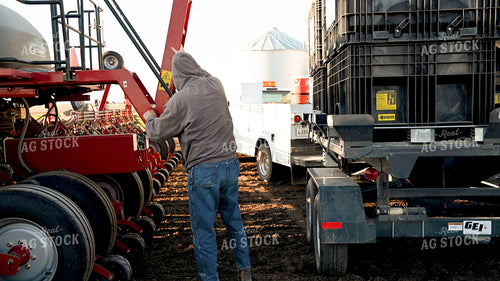Farmer Loading the Planter with the Seed Tender 25186