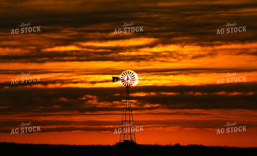 Farm Windmill Silhouette Against Dramatic Orange Sunset Sky 404032