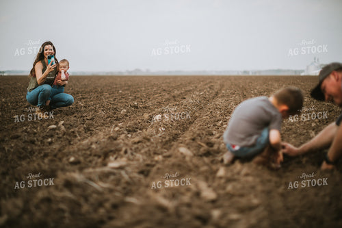 Farmer and Farm Kid Checking Seed Depth While Farm Mom Takes a Photo 5660