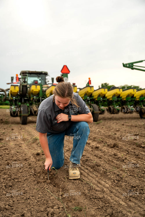 Female Farmer Checking Seed Depth Behind Planter 115698
