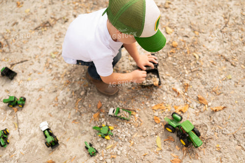 Farm Kid Playing with Toy Tractors 185075