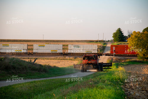 Combine Waiting for Train at Railroad Tracks 25446