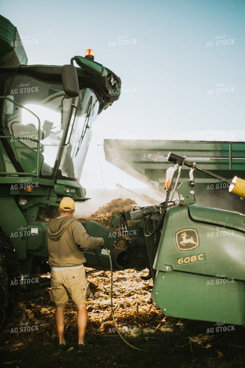 Farmer Cleaning Combine with Air Hose 4662