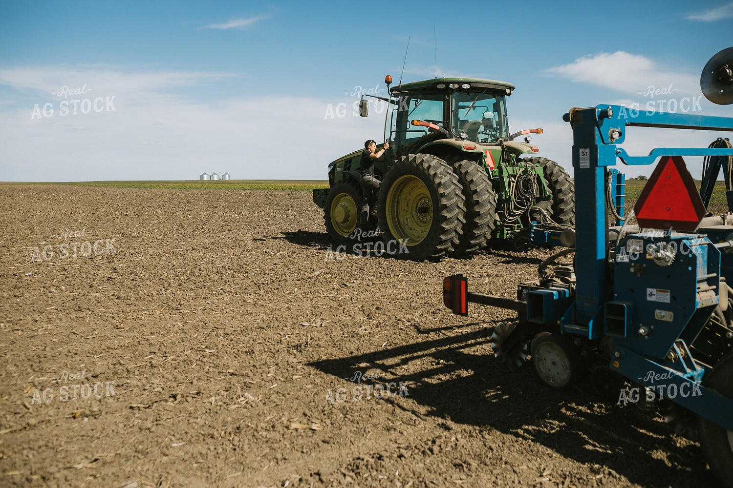 Farmer Climbing into Tractor with Planter 4282