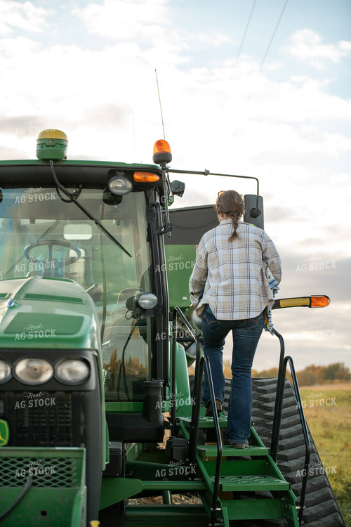 Female Farmer Climbing into Tractor 76551