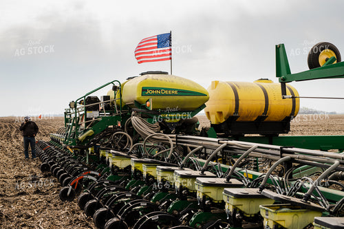 Farmer Talks on Phone Beside Planter in Field 133005