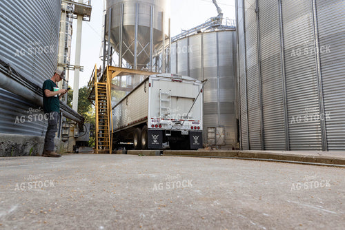 Farmer using Phone while Dumping Semi 79669