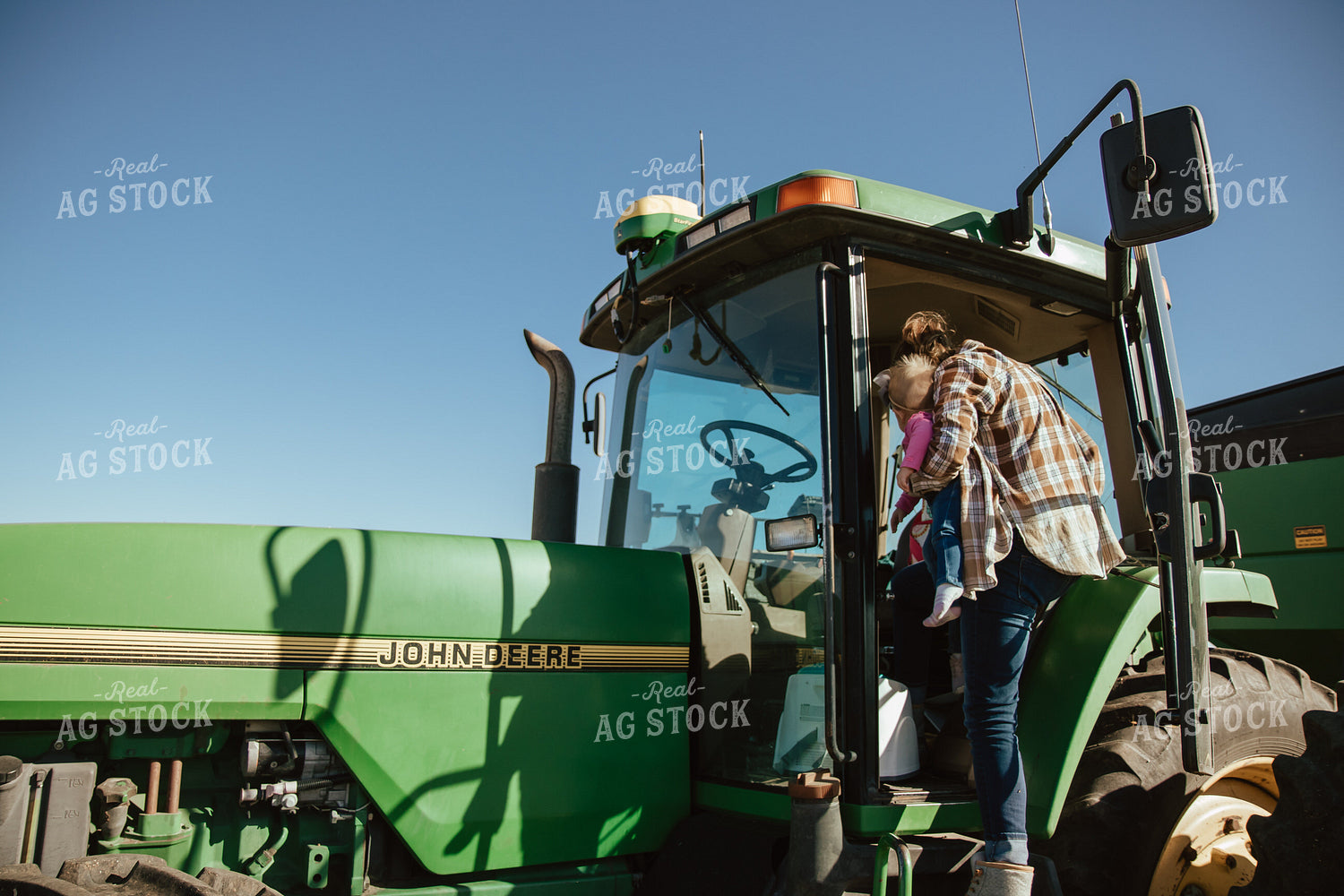 Female Farmer Loading Kids into Tractor 67541