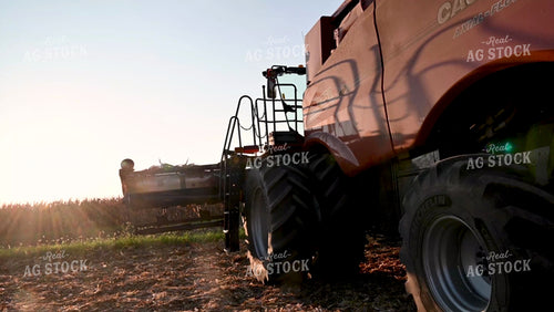 Farmer Climbing into Combine at Sunset