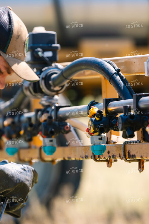 Farmer Fixing Sprayer Nozzles 52722