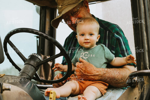 Farm Kid Sits on Grandpa's Lap in Tractor Cab 101038