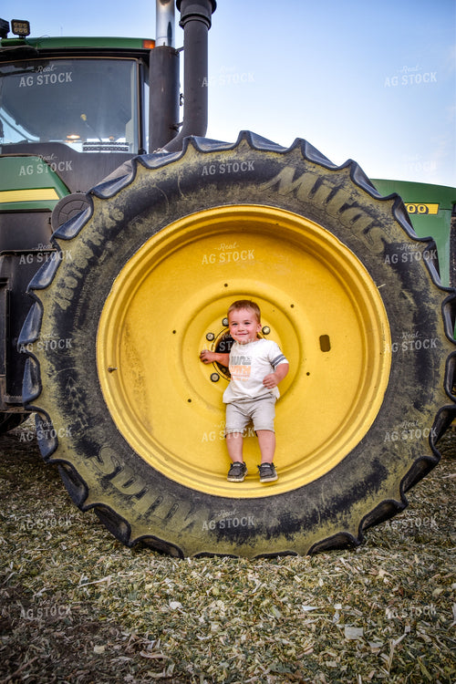 Toddler in Wheel of Tractor 56522
