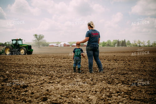 Farm Kid and Mom Watching Tractor in Field 169091