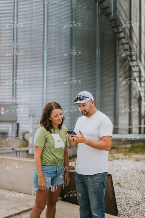 Farmer & Farm Wife Looking at Phone by Grain Bin 8763