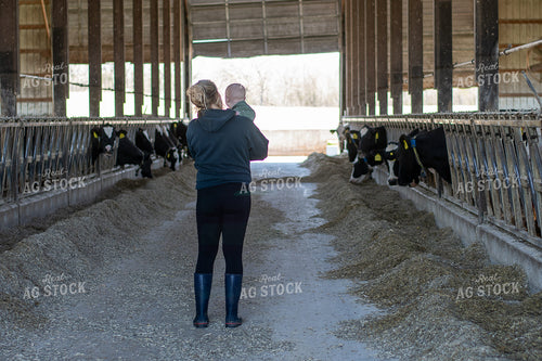 Female Farmer and Son with Holsteins in Barn 50495