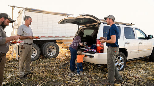 Family Enjoying Harvest Meal in the Field 25790