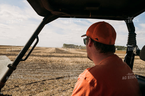 Farmer in Side by Side Watching Harvest 204020