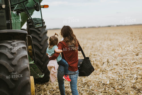 Female Farmer with Daugther Climbing into Tractor 8570