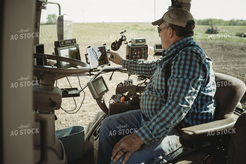 Farmer Adjusting Planter Monitor 4289
