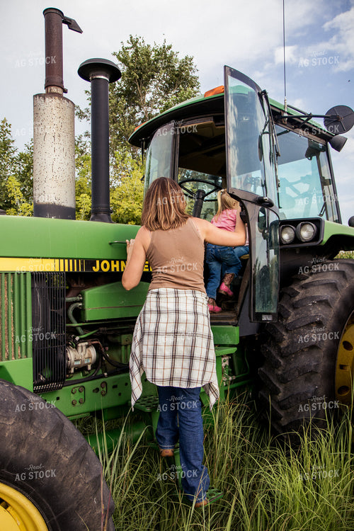 Female Farmer Getting into Tractor with Daugthers 67377
