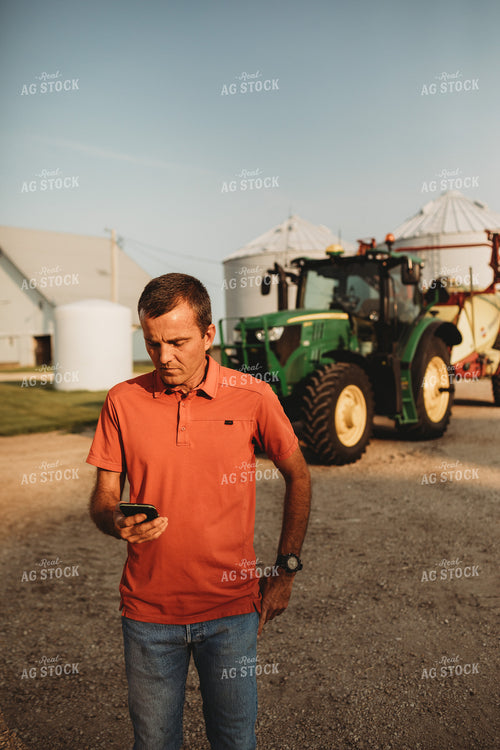 Farmer on Phone Outside of Tractor 4531