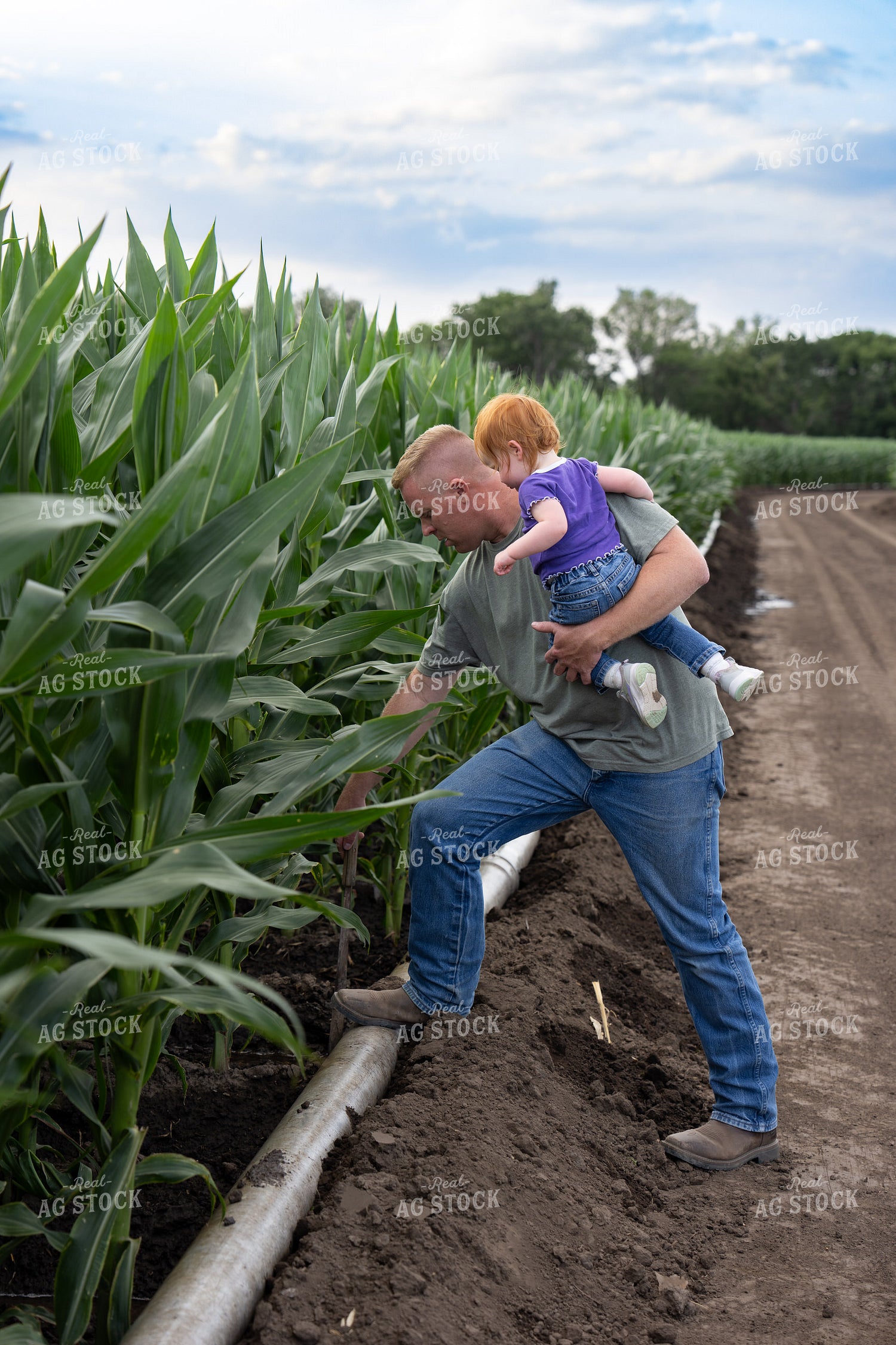 Farmer and Farm Kid Checking Gated Irrigation Pipe 65875