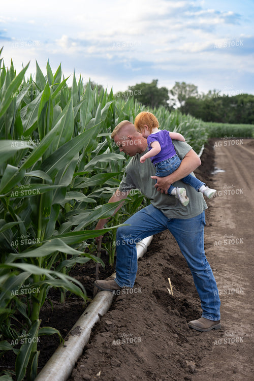 Farmer and Farm Kid Checking Gated Irrigation Pipe 65875