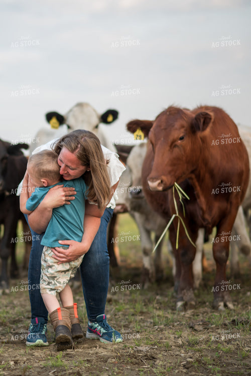Female Farmer Hugging Kid in Cattle Pasture 76559