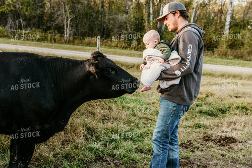Rancher with Baby and Cattle in Pasture 64159
