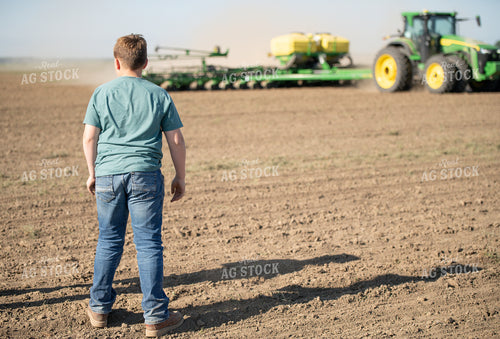 Boy Watching Tractor in Field 86041